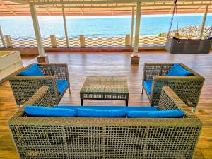 a room with chairs and tables and the ocean at ETHER Marari Beachfront in Mararikulam +71 photos