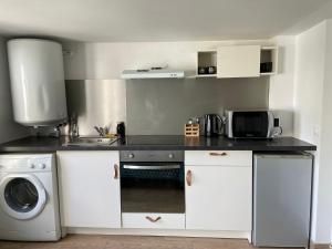 a kitchen with a sink and a washing machine at Studio One proche ligne 14 Kremlin Bicêtre in Arcueil