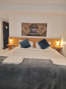 a bedroom with a large bed with blue pillows at BH Cozy Paradise Patong in Patong Beach