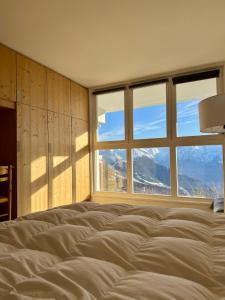 a bedroom with a bed with a large window at Le Nid Lumiere in LʼHuez