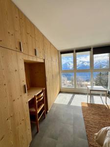 a bedroom with a desk and a table and windows at Le Nid Lumiere in LʼHuez