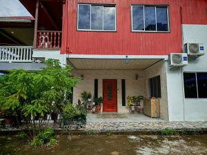 a red and white house with a red door at Forest Way Home Sepilok Sandakan in Sandakan