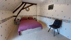 a bedroom with a bed and a chair in it at Maison centre ville in Nogent-sur-Vernisson