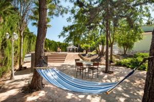 a hammock in a park with a table and chairs at Casa rural cavila in Pliego
