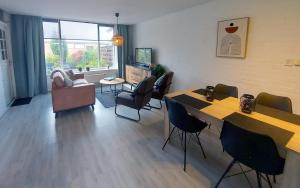 a living room with tables and chairs and a couch at Plattedijk - vakantiehuis 25-41 in Lemmer