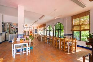 a restaurant with wooden tables and chairs and windows at Kampaoh Benicàssim in Benicàssim