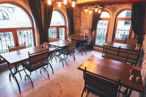 a restaurant with wooden tables and chairs and windows at Elite Rose Cappadocia in Uçhisar