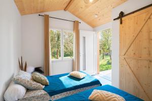 a bedroom with two beds and a large window at L'Envol in Eyliac