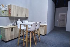 a kitchen with a white table and white chairs at Gagarin Hotel in Almaty