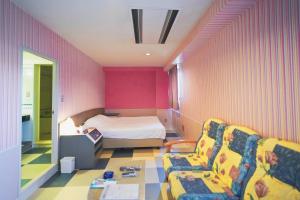 a bedroom with a bed and a couch and a chair at ホテル韮崎インター in Nirasaki