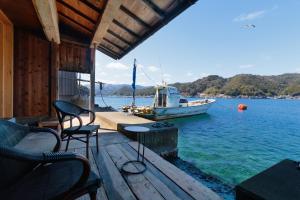 un barco en el agua con una mesa y sillas en 漁師の宿あっちゃん, en Ine