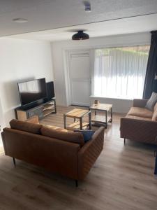 a living room with a couch and a tv at Vakantiewoning Oase in Groede