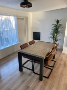 a dining room with a wooden table and chairs at Vakantiewoning Oase in Groede