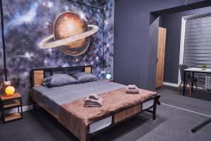 a bedroom with a bed with a planet mural on the wall at Gagarin Hotel in Almaty +6 photos