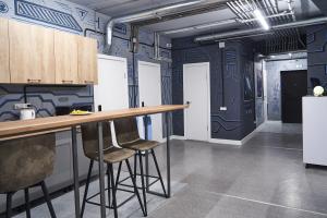 a kitchen with blue walls and a bar with stools at Gagarin Hotel in Almaty