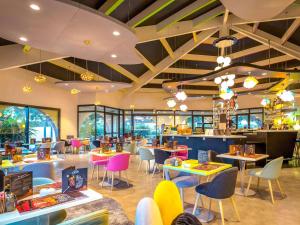 a restaurant with tables and chairs and a cafeteria at ibis Styles Fréjus St Raphael in Fréjus
