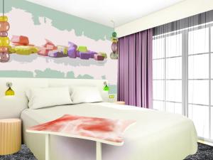 1 dormitorio con cama blanca y cortinas moradas en ibis Styles Fréjus St Raphael, en Fréjus