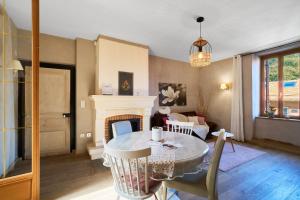 a living room with a table and a fireplace at L'Envol in Eyliac