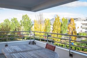 a balcony with a table and chairs and trees at Beauregard- Charmant 2 chambres, terrasse & garage in Annecy