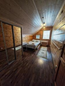 Habitación con cama en una cabaña de madera en Homely Loft, en Punkaharju