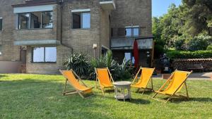 four chairs and a table in front of a house at Casa Momi b&b and in Novilara