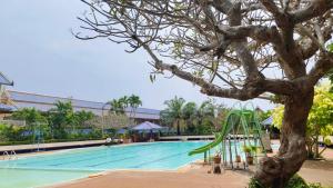 a swimming pool with a tree and a slide at Sinsiam Resort in Ban Ang