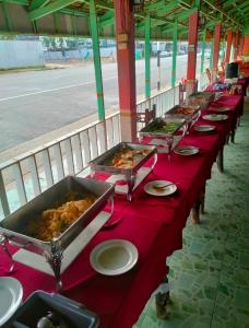 a row of buffet tables with food on them at Sinsiam Resort in Ban Ang +12 photos