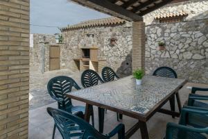 Una mesa y sillas en un patio con una pared de piedra. en Casa Carmelo Conil 2, en Conil de la Frontera