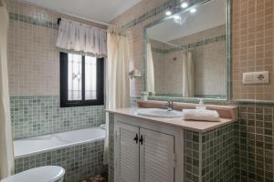 Un baño con lavabo, bañera y espejo. en Casa Carmelo Conil 2, en Conil de la Frontera 18 fotos más