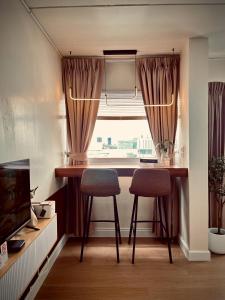 Una pequeña cocina con una mesa y dos sillas. en Happy House T8, en Thung Si Kan