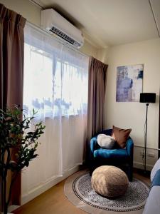sala de estar con silla azul y ventana en Happy House T8, en Thung Si Kan