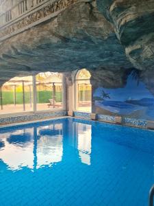 a pool in a cave with a rock wall at Sokoterme Hotel in Soko Banja