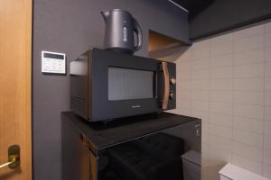 a microwave sitting on top of a television on a fireplace at The LANG HOTEL in Fukuoka