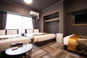 a hotel room with two beds and a table at The LANG HOTEL in Fukuoka