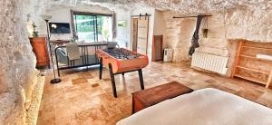 a living room with a table in the middle of a room at Troglo la Roche Tourangelle et vélos in Civray-de-Touraine