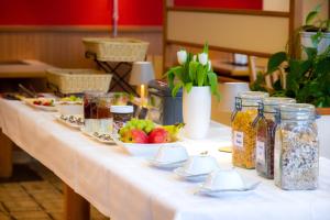 a table with a white table cloth with food on it at Hotel Cafe Kern in Großostheim