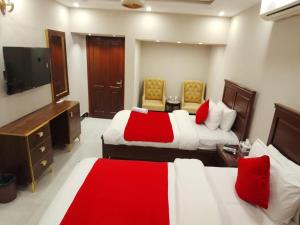 a hotel room with two beds and a flat screen tv at Hotel BlueSky Clifton 2 in Dargai