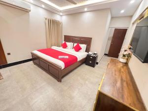 a bedroom with a large bed with red pillows at Hotel BlueSky Clifton 2 in Dargai