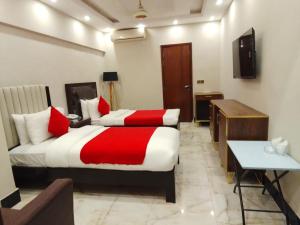 a hotel room with a large bed and a desk at Hotel BlueSky Clifton 2 in Dargai