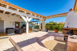 an outdoor patio with a fireplace and an outdoor kitchen at Chez Gaston - Chambre in Saint-Drézéry