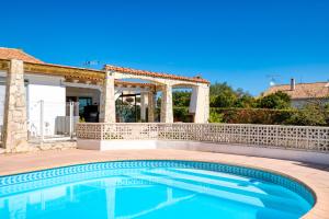 a swimming pool in front of a house with a gazebo at Chez Gaston - Chambre in Saint-Drézéry