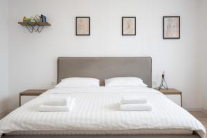 1 dormitorio con 1 cama blanca grande y 4 almohadas en Therme Voyage Studio 6, en Otopeni