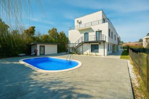 a house with a swimming pool in front of a house at Therme Voyage Studio 6 in Otopeni