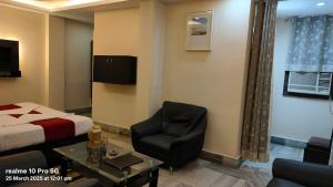 a hotel room with a bed and a chair at New Shanti Hotel in Prayagraj