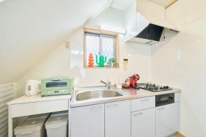 a small white kitchen with a sink and a window at LEGOLAND 近くの一軒家Nagoya Cozy Nest House in Shimono-ishikichō