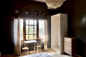 a bedroom with a window and a desk and two stools at Aiwan Hostel & Luggage storage in Sanur