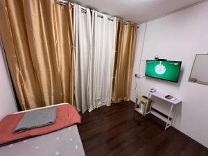 a room with a bed and a television in it at Labuan Homestay Jangmi,Jaseumin CabinRoom in Labuan