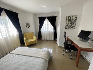 a bedroom with a desk and a bed and a desk and chair at Sandalwood Property in Lusaka
