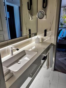 a white bathroom with a sink and a mirror at The Wings Hotels Pera in Istanbul