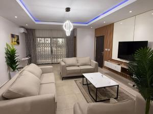 a living room with a couch and a tv at Fohtung Crest in Abuja